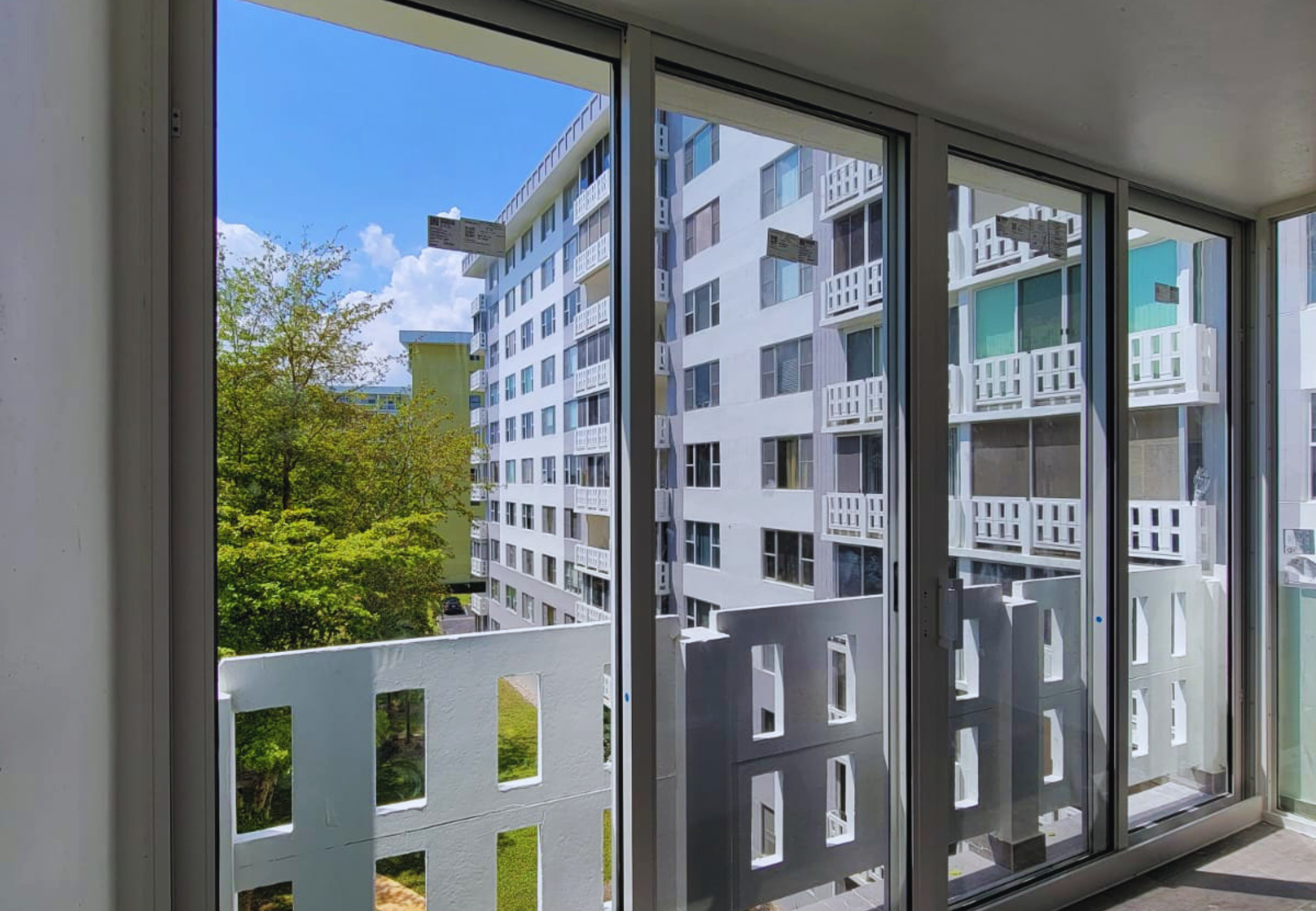 Impact-rated sliding glass doors installed in a South Florida condominium by Safetech Roofing and Windows