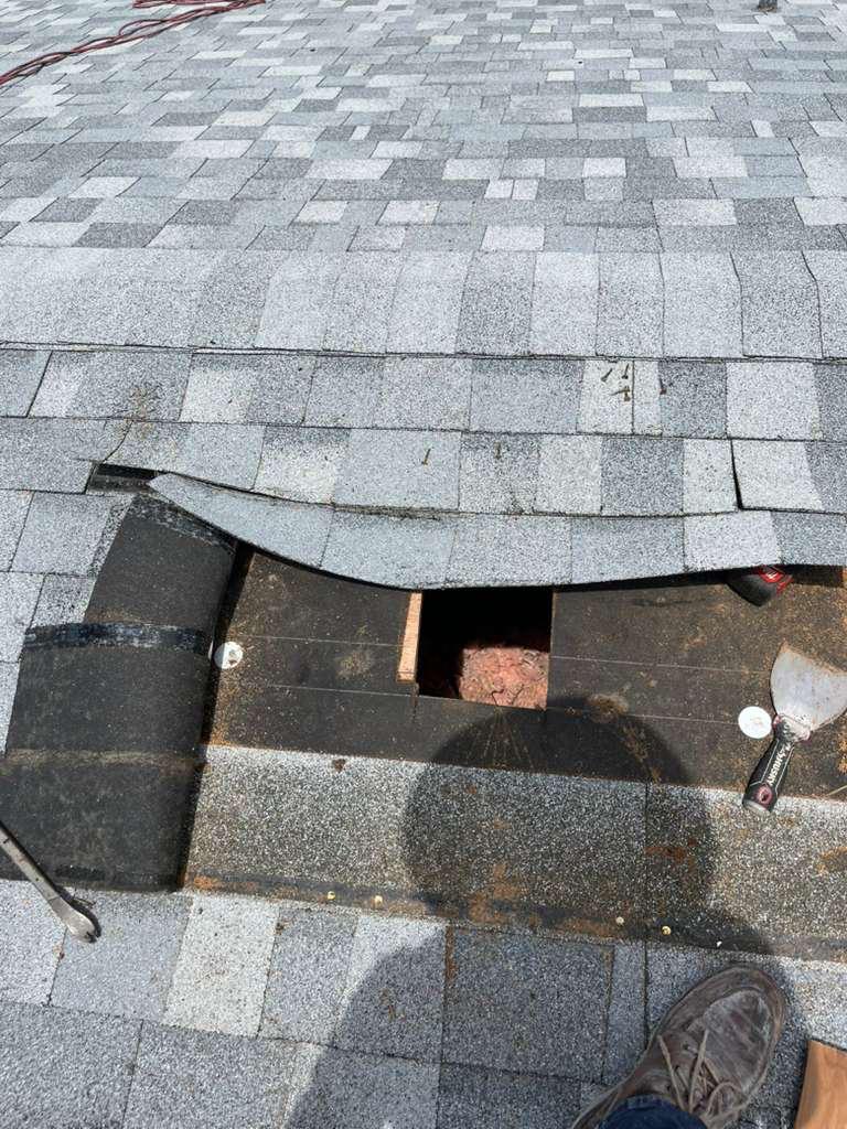 Architectural shingles cut back and roof decking opened between the rafters for a new kitchen exhaust penetration on a Broward County shingle roof
