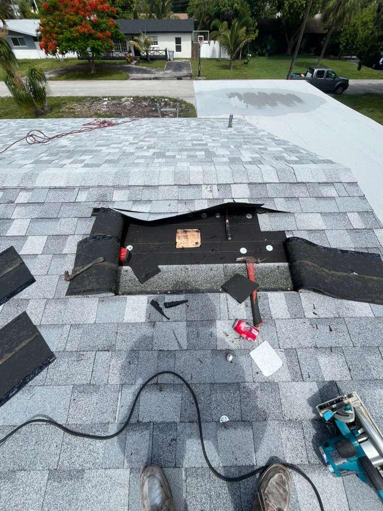 New plywood decking patch fastened with plate washers and underlayment folded back around a kitchen exhaust opening on a Broward County shingle roof