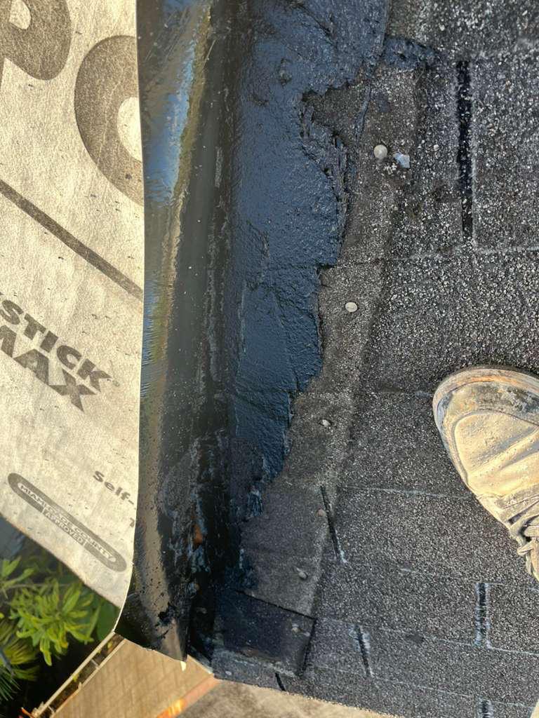 Shingle course lifted to expose torn underlayment beneath, during a shingle roof leak repair in Broward County, Florida