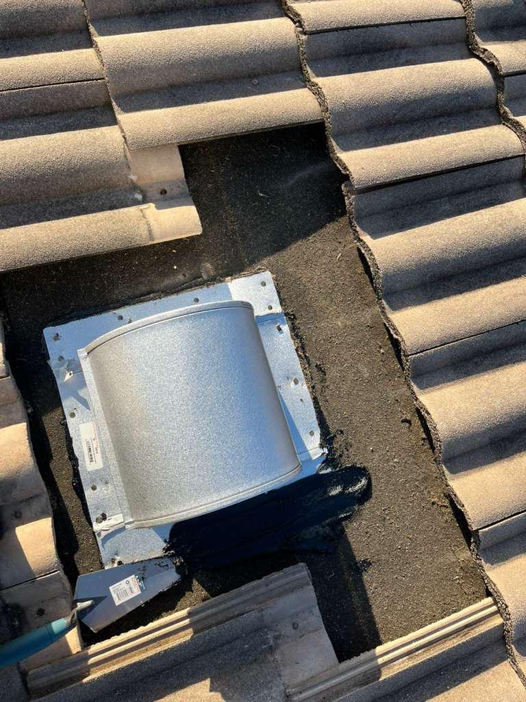 New galvanized goose-neck vent and flashing plate set into mastic on a tile roof in Broward County, Florida