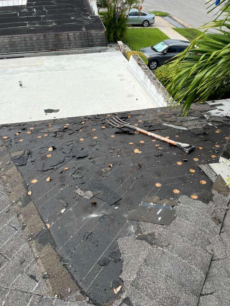 Shingles stripped back to the old underlayment and plate-washer fasteners during a leak repair on a Broward County shingle roof