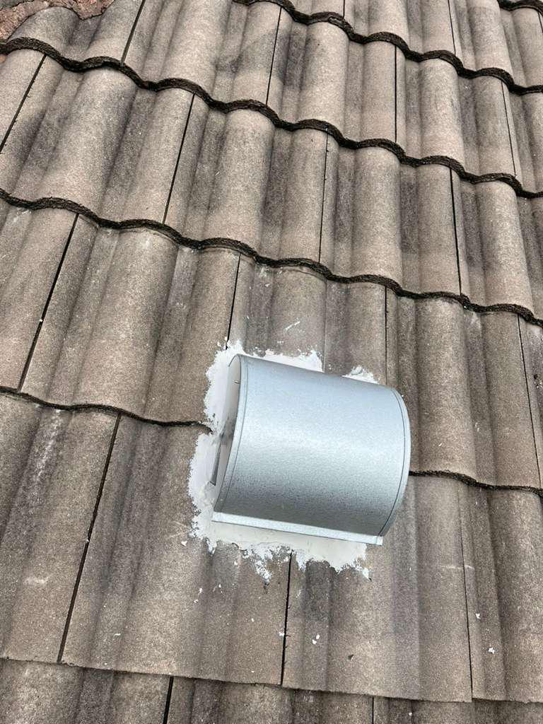 Tile adhesive pointed around a replacement goose-neck vent to close the gap on a Florida tile roof