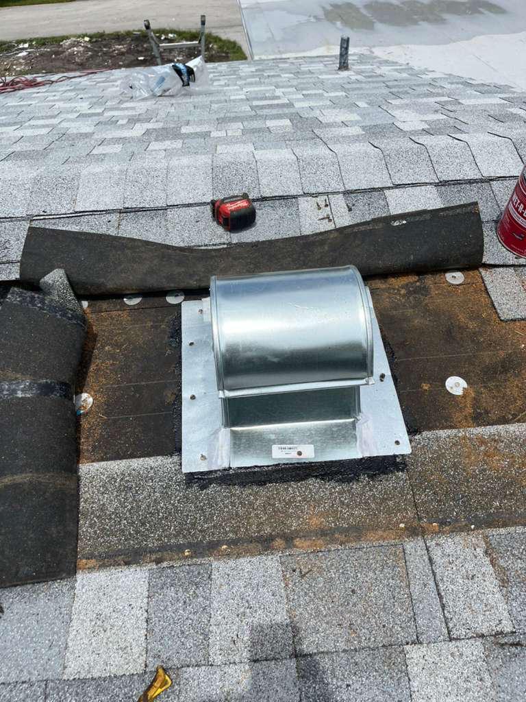 New architectural shingles installed over a repaired section of roof after a rotted goose-neck vent was replaced in Broward County, Florida