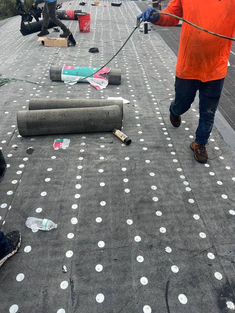Crew working the field on a low-slope commercial roof