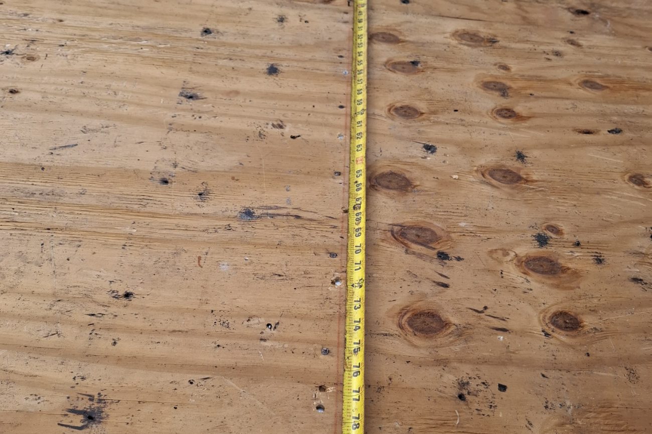 Tape measure documenting nail spacing along a run of roof sheathing