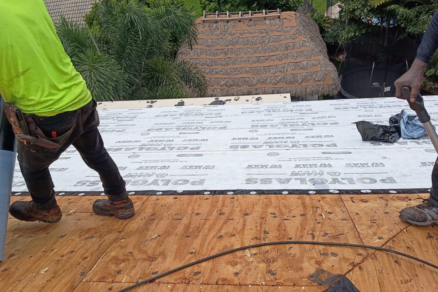 Two roofers working across a large area of installed self-adhered underlayment