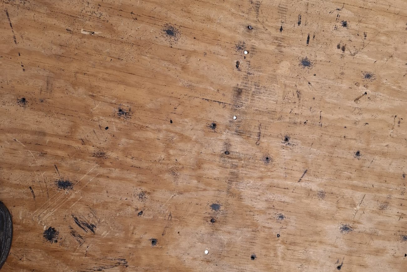 Close view of a re-fastened plywood roof deck showing the fresh nail pattern across the sheets