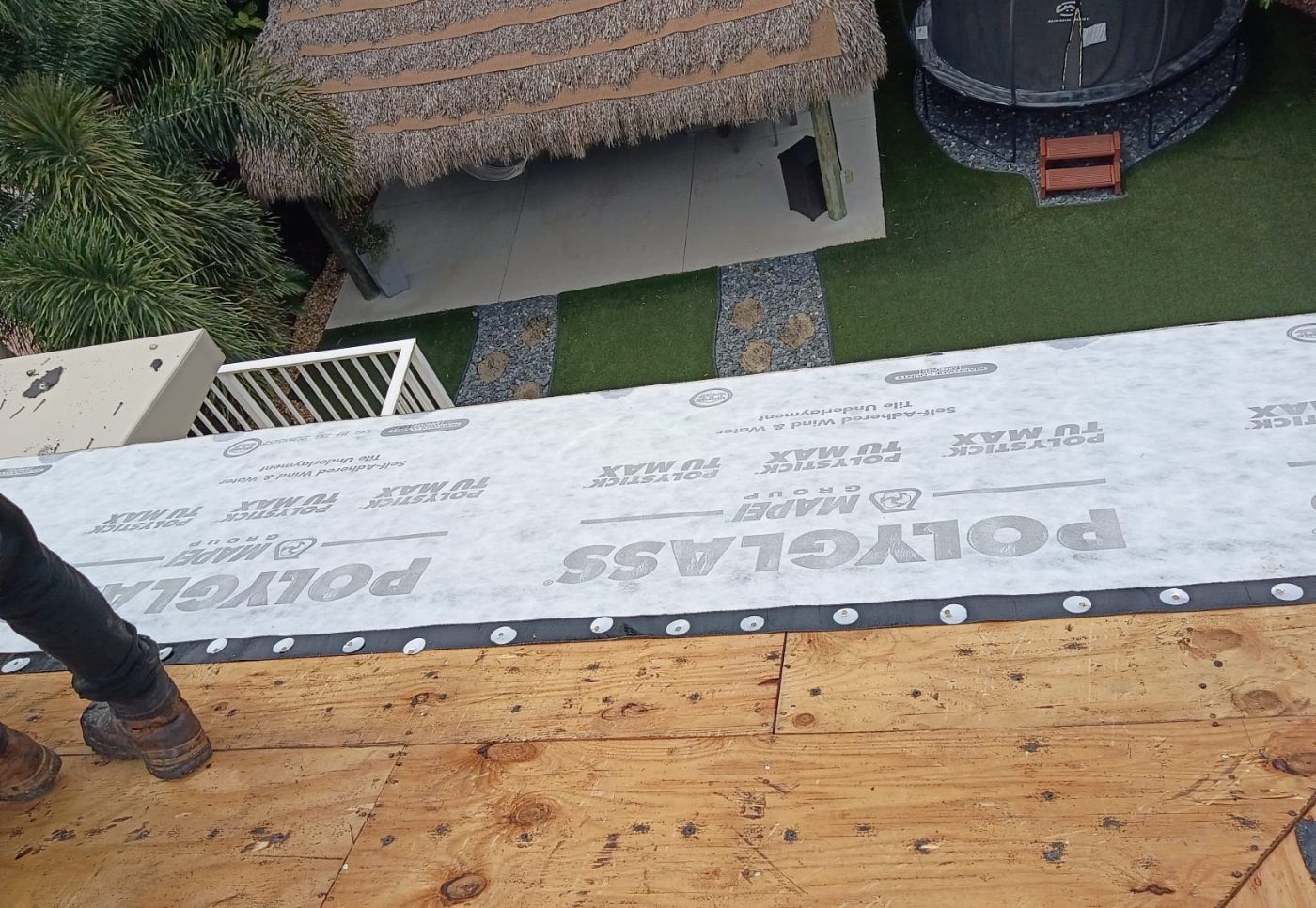 Self-adhered underlayment installed at a roof eave with cap fasteners along the lower edge