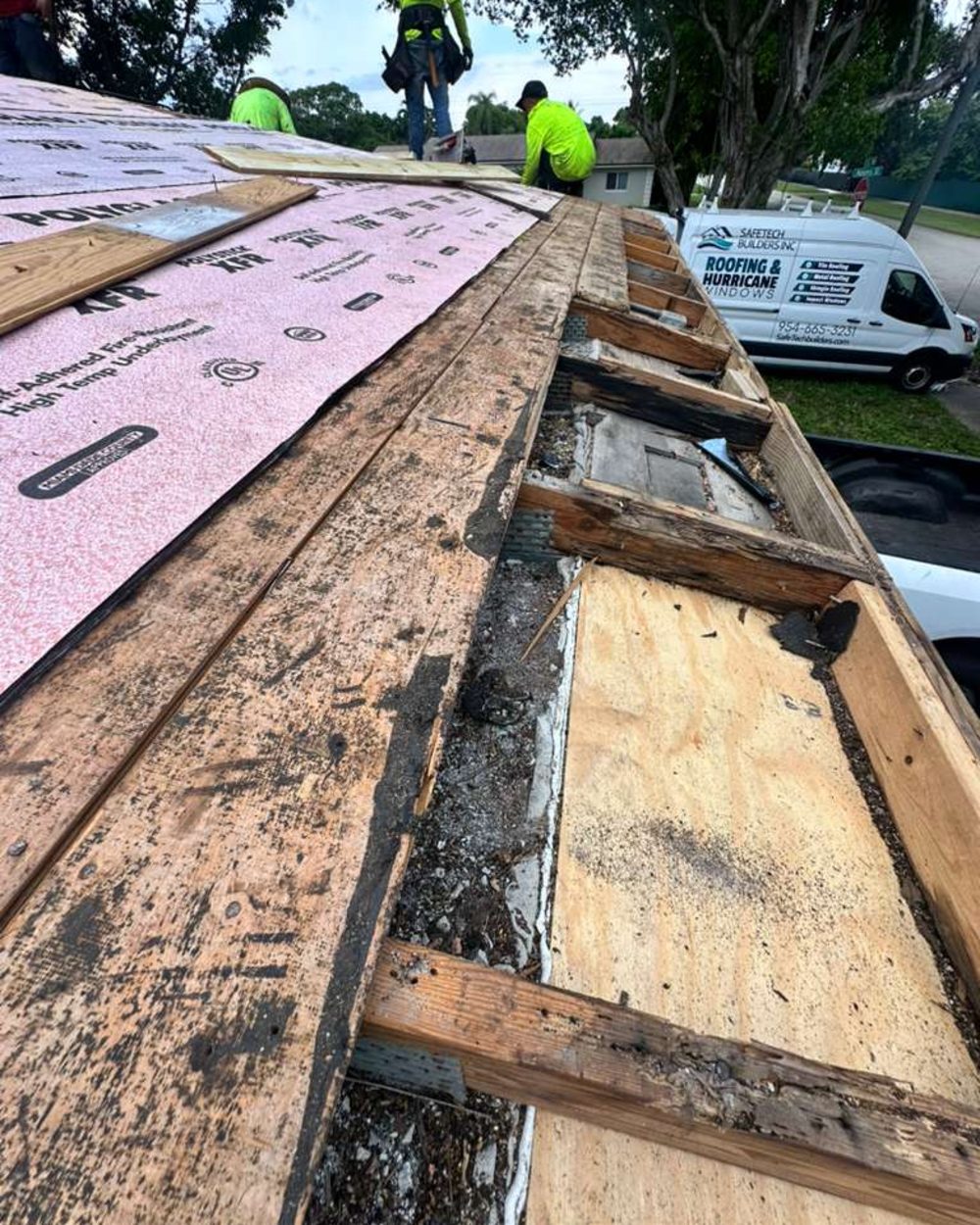 Safetech Builders Roofing and Windows crew working on a roof replacement with the deck open along the wall line