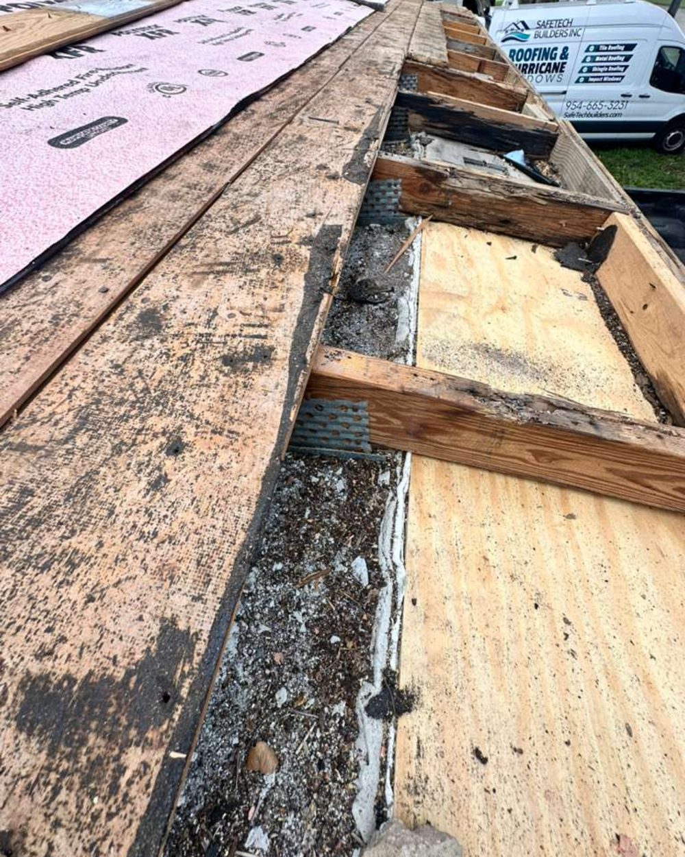 Roof deck partially removed during a replacement, exposing the run of truss ends along the exterior wall