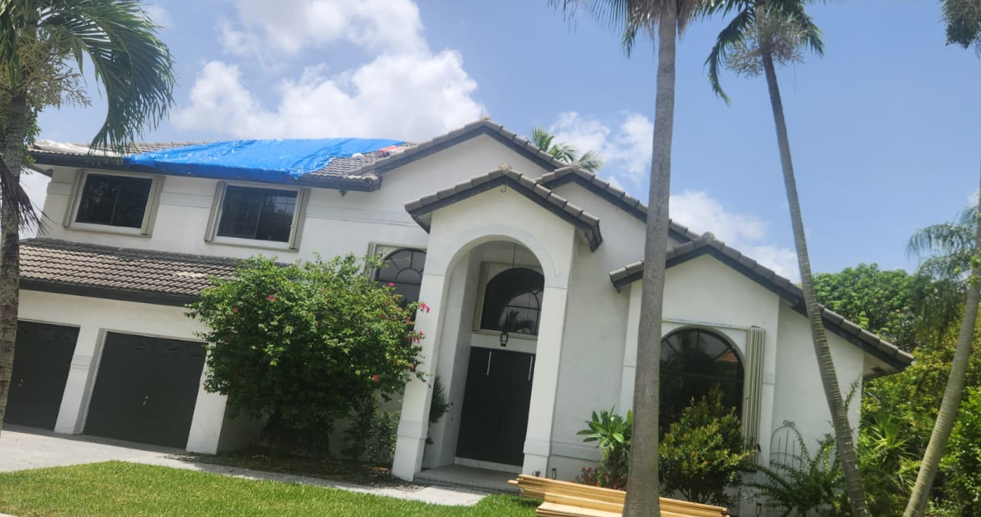 Emergency tarp protecting a storm-damaged roof on a Pembroke Pines building