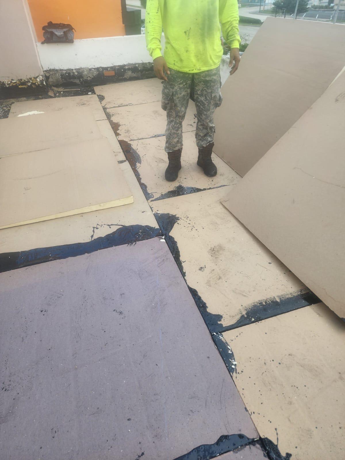 Tapered polyisocyanurate insulation laid to build drainage slope on a commercial flat roof in Broward County, Florida