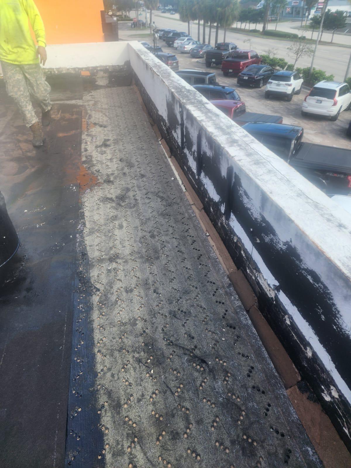 Base sheet carried up the parapet wall as flashing on a commercial flat roof in Broward County, Florida