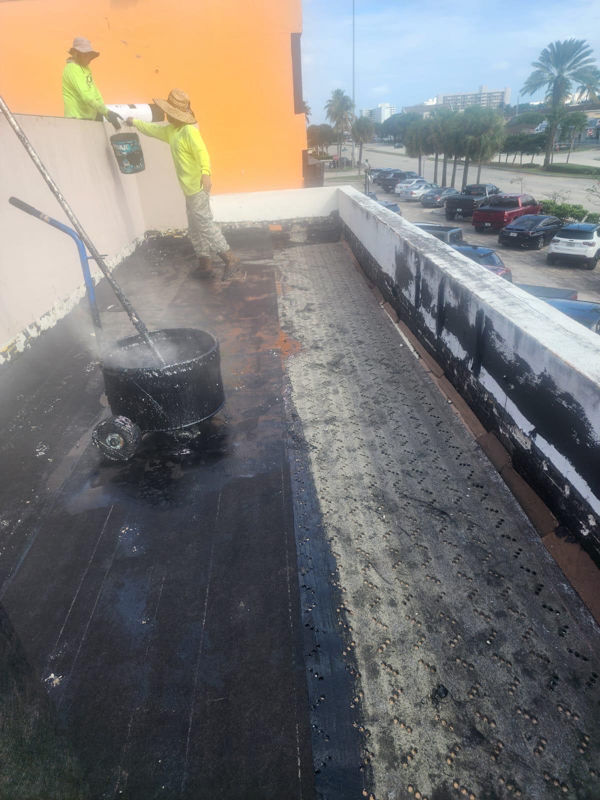 Ply sheet hot-applied over the base sheet on a commercial flat roof in Broward County, Florida