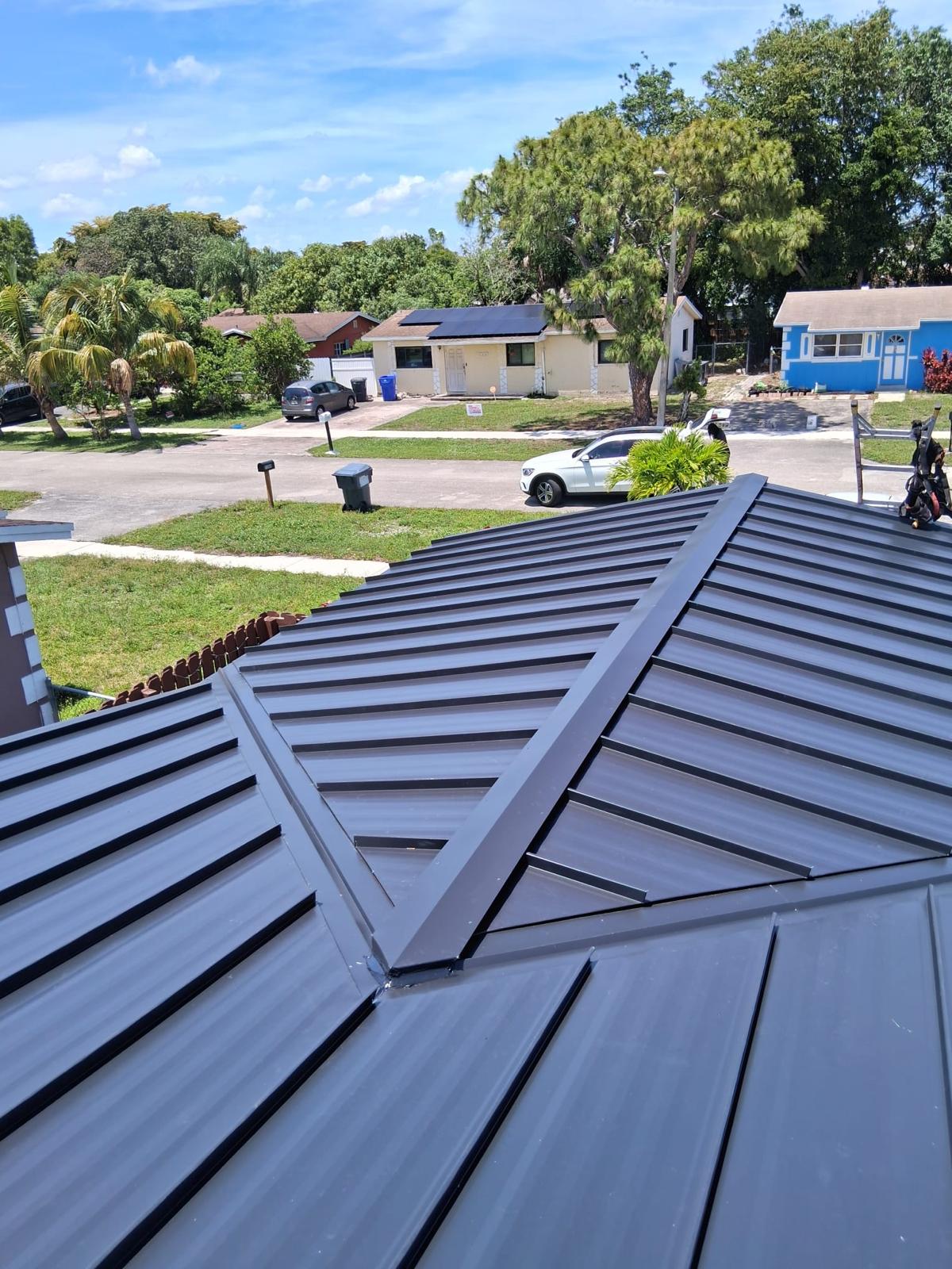 Dark standing-seam metal roof ridge detail in Broward County, Florida