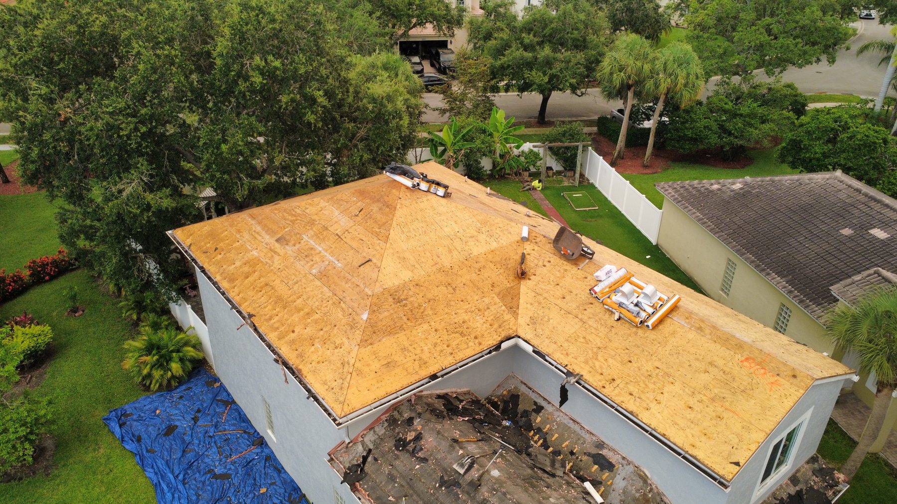 Repaired plywood roof decking on a Broward County home with rolls of Polyglass Polystick underlayment staged for install