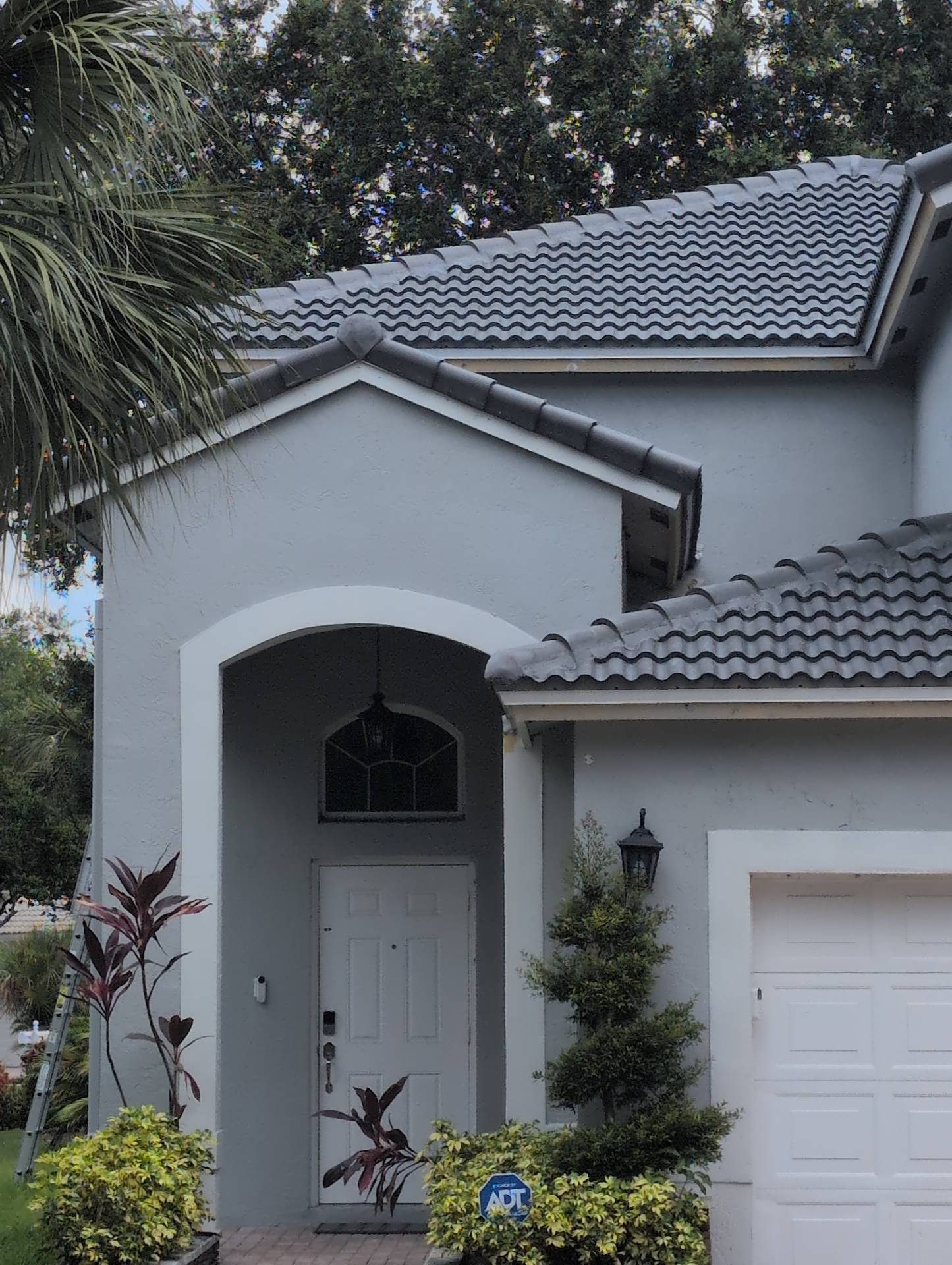 Completed tile roof at the entry of a Broward County home, courses finished and hip line closed