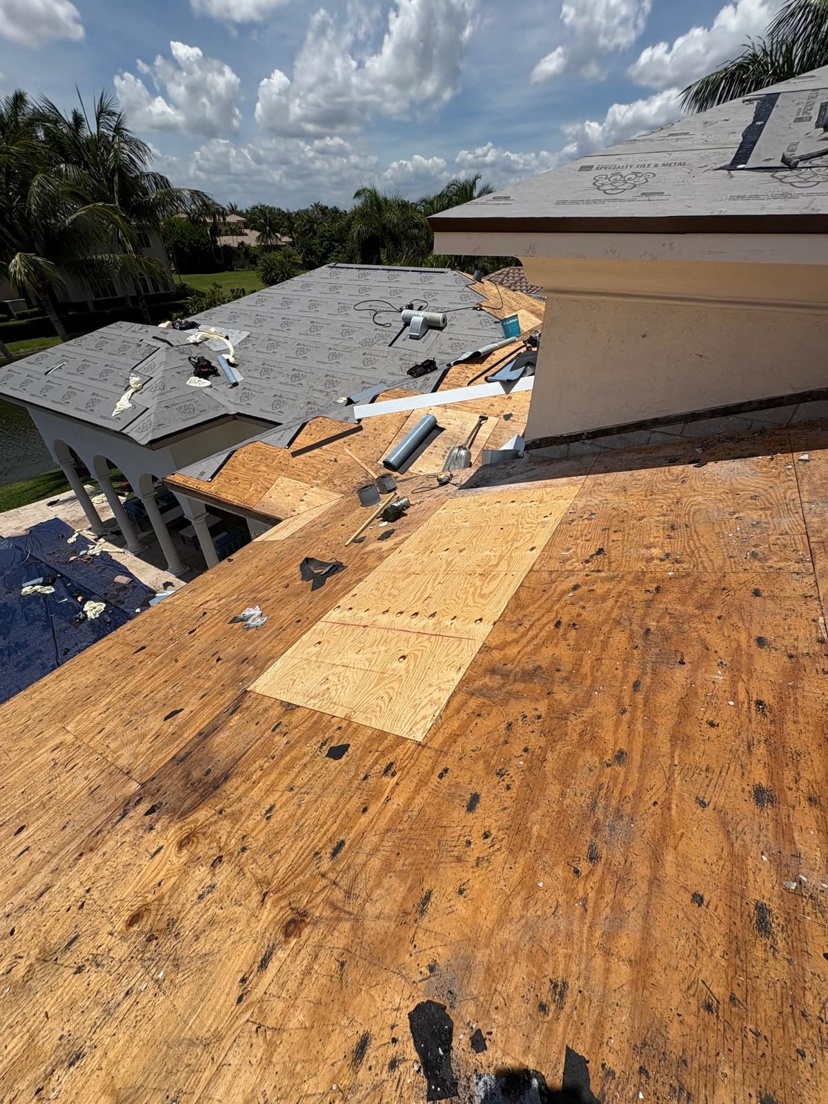 Polyglass Polystick XFR self-adhered underlayment being installed and fastened on a Broward County shingle roof