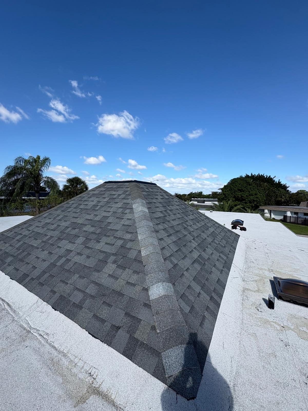Charcoal architectural shingles installed to the eave line on a Broward County home