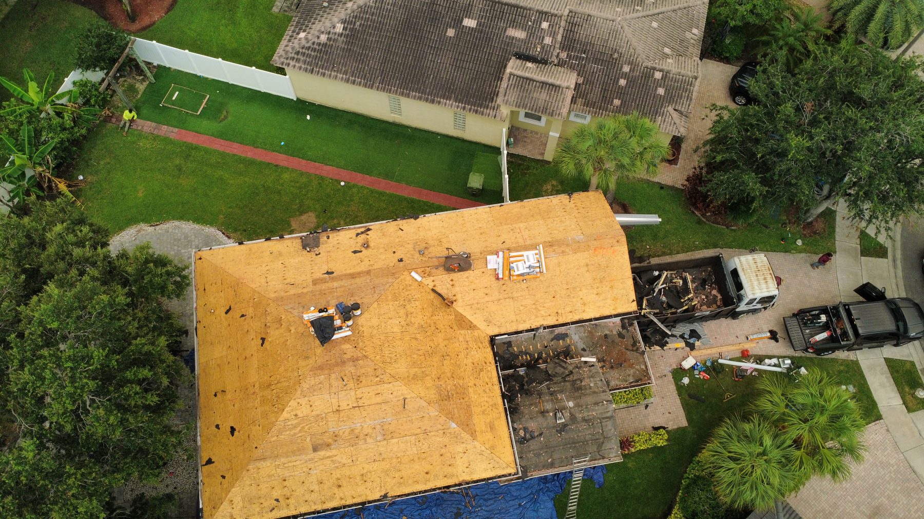 Fresh CDX plywood decking installed and code-nailed on a Broward County tile re-roof, drone view