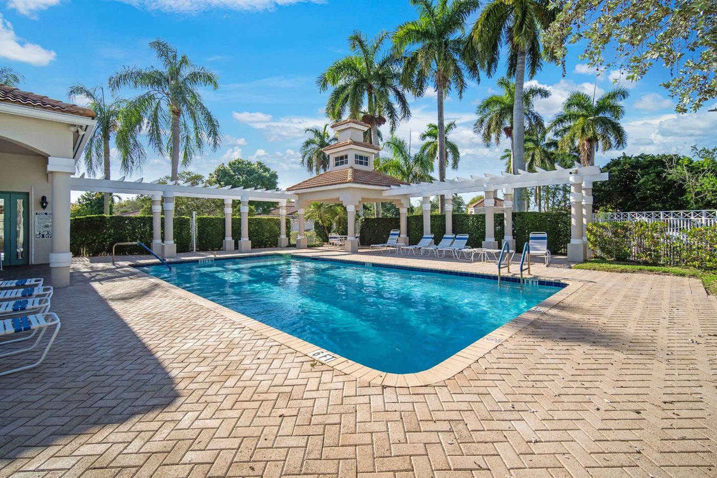 Community pool and pergola with a tile-roofed cupola in a Fort Lauderdale, Florida neighborhood