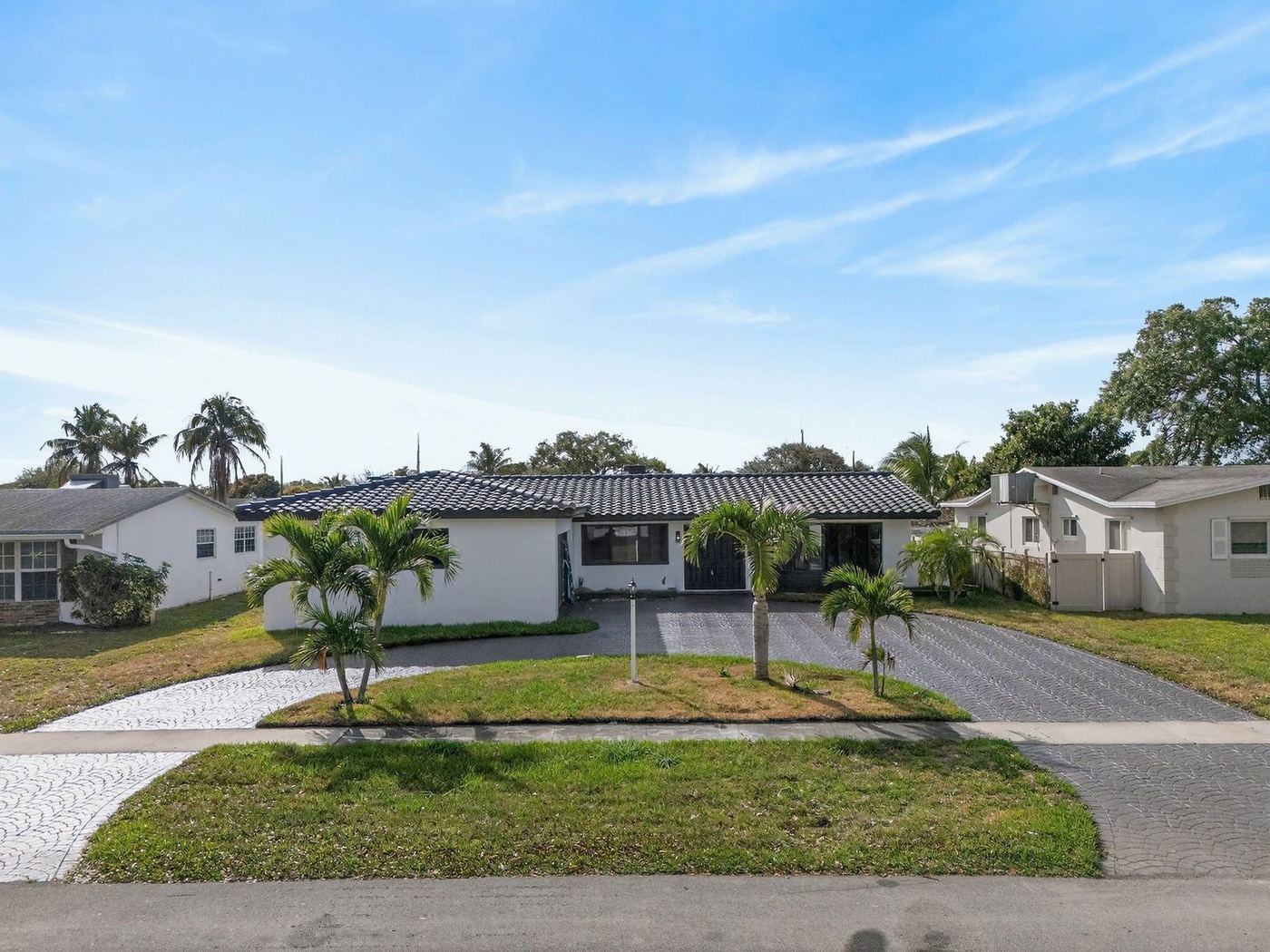 Single-story ranch home with a dark concrete tile hip roof in South Florida