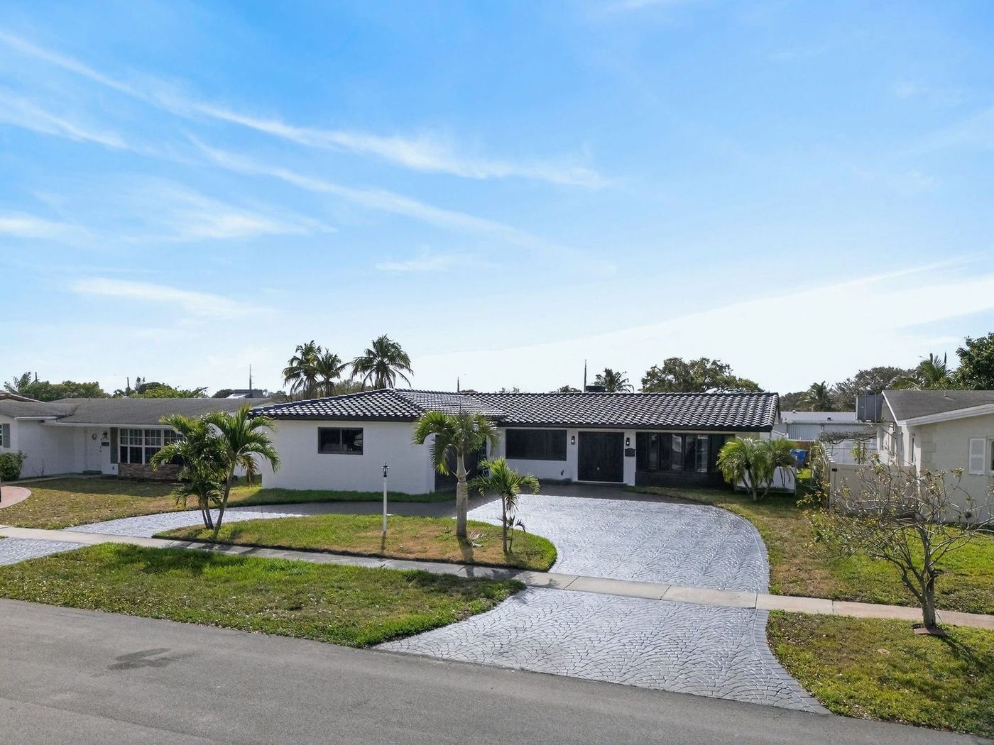 Dark concrete tile roof on a white single-story home seen from the street in South Florida