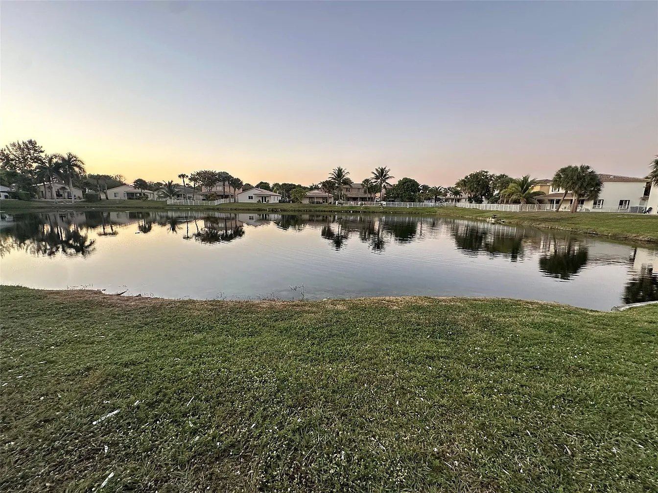 Lake and tile-roofed homes at dusk in a Miramar, Florida neighborhood