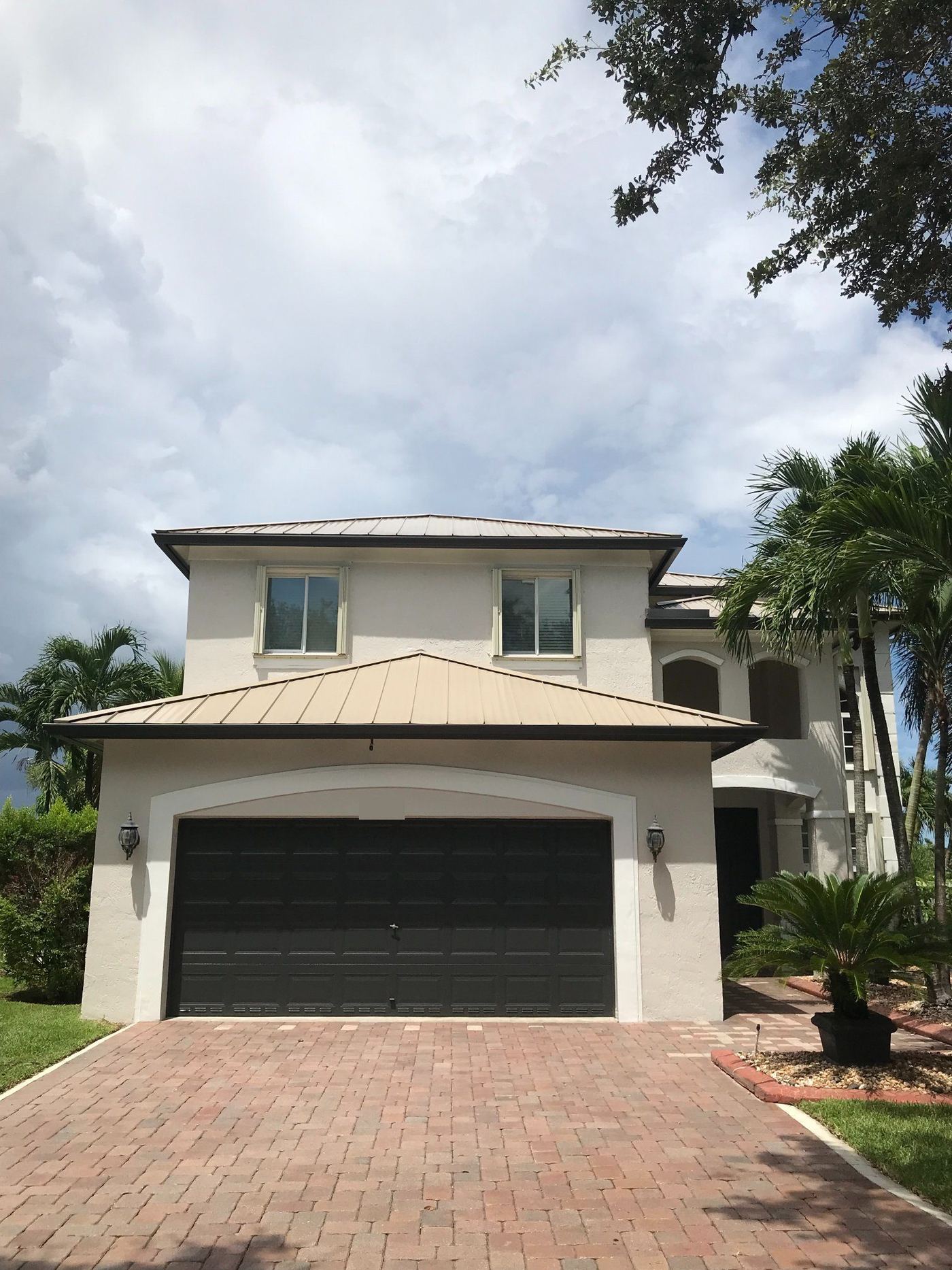 Two-story home with a tan standing-seam metal roof in Miramar, Florida