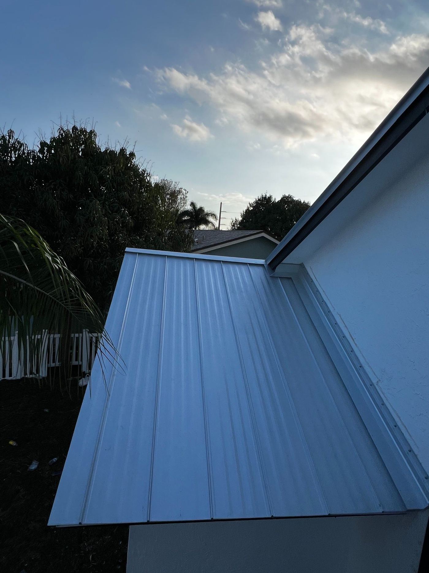 Metal roof panel edge and wall flashing on a South Florida home