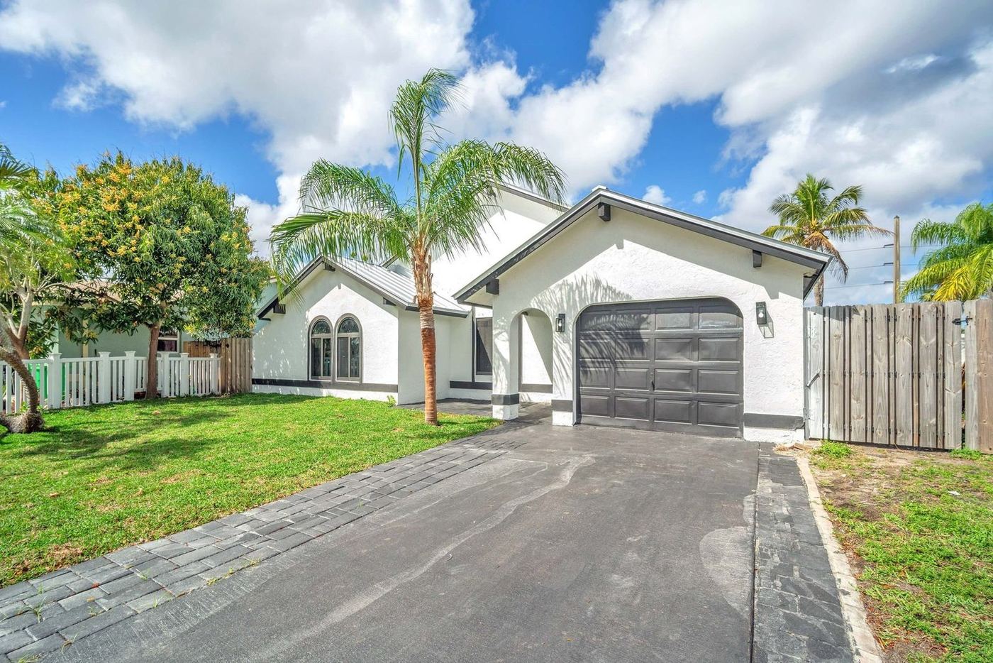 Single-story white home with a metal roof in Sunrise, Florida