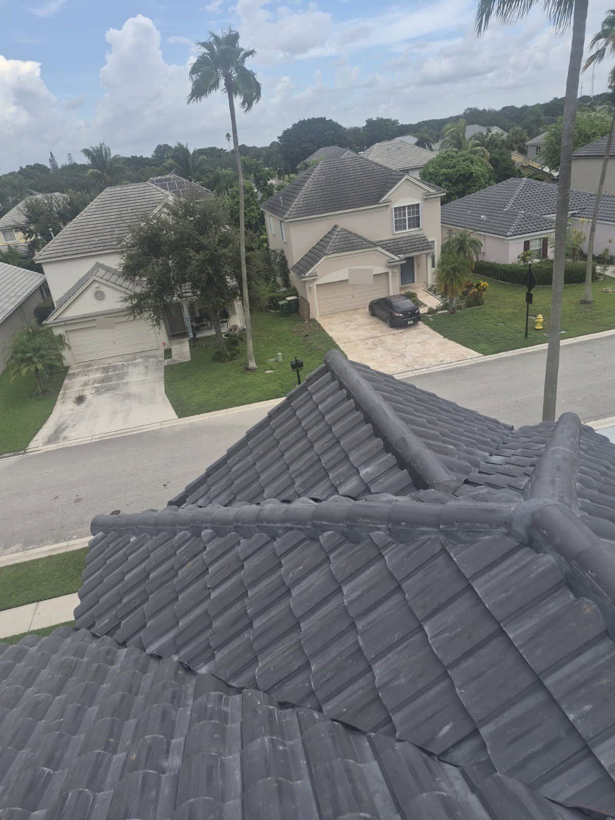 New charcoal barrel tile roof completed by SafeTech in Tamarac, Florida, above a street of tile-roofed homes